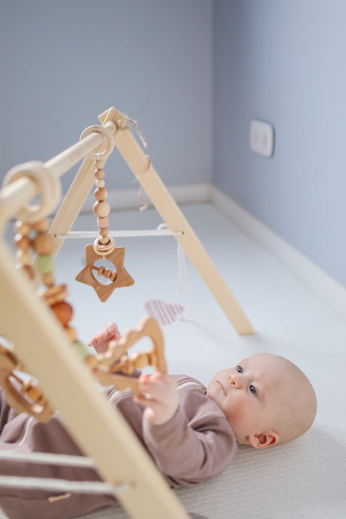 Cute toddler playing with wooden rattle