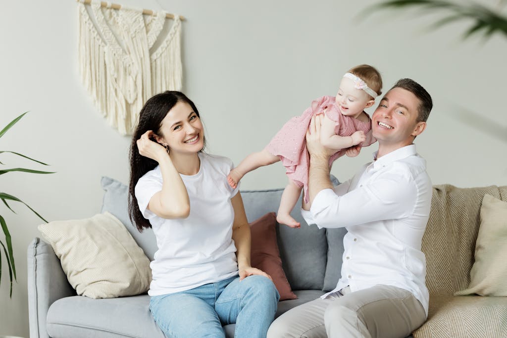 Photo of a Couple Sitting With a Baby