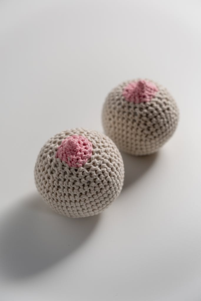 Crochet breast-shaped toys placed on a white background, representing anatomy creatively.